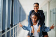 © AS Photo Family - Two african woman friends in jeans jacket having fun, jumped on shoulders indoor together.