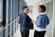 © AS Photo Family - Two african woman friends in jeans jacket posed indoor together.