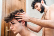 © Pol Sole/ADDICTIVE STOCK - Male with hair trimmer cutting hair of guy in contemporary bathroom at home