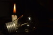 © gunawan - a lamp and one candle blur burning in the dark background. power outage. blackout begin.