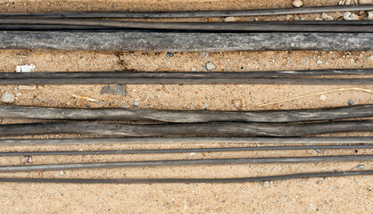 wires of different thickness lie on the sand with stones 