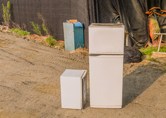 two old abandoned refrigerators