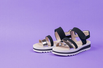 Stylish women's summer sandals on a rich lilac background.