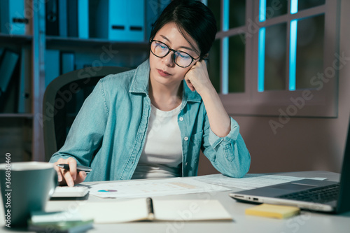 Cuadros en Lienzo Close up of woman freelance worker using calculator while going through company finances in dark night