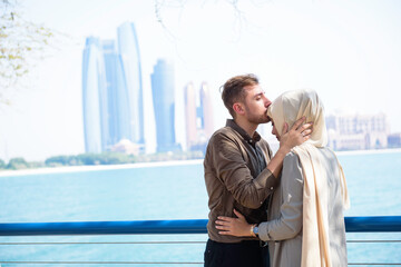 Romantic Middle Eastern couple embraces and guy  kisses female forehead