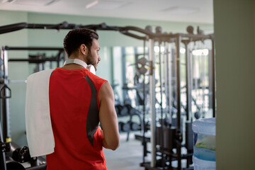 Rear view of male athlete entering the gym.