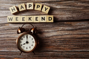 Wall Mural - happy weekend alphabet letter with alarm clock on wooden background;