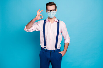 Sticker - Portrait of his he attractive healthy guy traveler wearing gauze mask showing ok-sign agree self isolation immunity care assistance insurance stop influenza isolated bright vivid blue color background