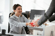 © JustLife - Young businessman giving his colleague present in office. Young man suprise beautiful businesswoman in office
