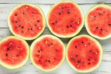 Round slices of watermelon on white wooden Provence style table.