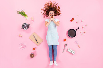 Sticker - Full length high angle above flat lay view photo of pretty housewife lady lying floor arms on cheeks wear kitchen apron cooking ingredients utensils cuisine isolated pink color background