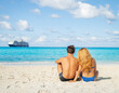 © rubchikova - Young couple sitting on the beach. Honeymoon on the island