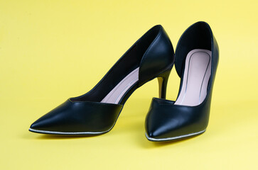 Women's black classic shoes on a yellow background