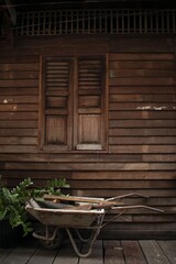 Canvas Print - Rustic background consisting of a wooden wall, window and a wheelbarrow