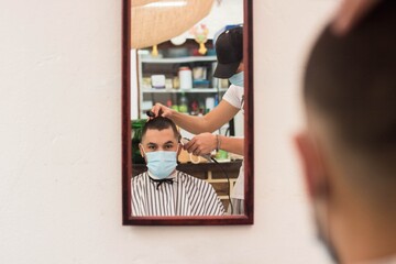 Canvas Print - Closeup shot of a young male getting a new stylish haircut in the barbershop