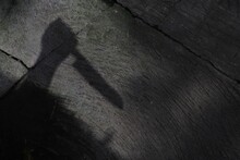 High Angle Shot Of A Shadow Of Human Hand Holding A Knife- Murder Concept