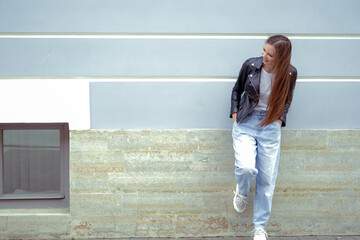 Young woman standing at blue wall in the city