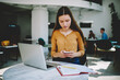 © BullRun - Pensive young female freelancer checking email box on mobile while working online in coworking space,concentrated hipster girl texting messages to friend discussing completing homework task in network