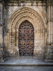 Poster - Vertical shot of a wooden door into an old building with eastern ornaments