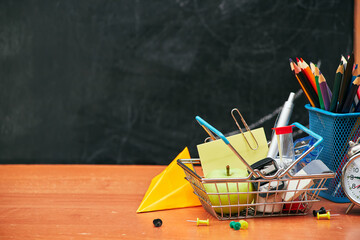 school still life, alarm clock, stand for pencils on the background of a school board, university, college, copy space