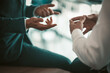 © Svyatoslav Lypynskyy - Two business people have conversation sitting on office desk. Close up shot of office workers hands. Tinted image.