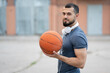 © Vladimir - Man with headphones stands on the street with a basketball in his hands