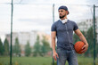 © Vladimir - Man with headphones stands on the street with a basketball in his hands