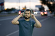 © Vladimir - Man with headphones listens to music late at night on a city street