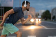 © Vladimir - An adult athlete jogs through the city at night, a man runs across a pedestrian crossing