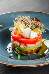 Wall Mural - Healthy fresh salad with avocado, tiger prawns, capers, tomato, poached egg in plate over dark table. Healthy vegan food, clean eating