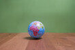 Weltkugel mit Blick auf Afrika, Europa und Asien auf Holztisch mit grünem Hintergrund