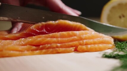 Wall Mural - Closeup of chef hands slice fresh red fish. Chef cuts salmon fillet.