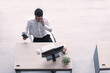© Arunporn - Top view of executive, manager, or engineer drinking coconut juice working on computer using smartphone in social distancing creative office.