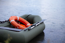 Inflatable Lifeboat With A Lifebuoy On Board Floats In The Lake During The Rain