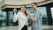 © Volodymyr - Curly and straight hair woman points a finger at something. Girl holding tablet pc. Business conversation between two young entrepreneur near office glass building. Communication concept.