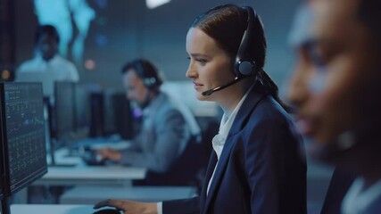 Wall Mural - Shifting Focus from a Young Male Technical Support Specialist to a Beautiful Female Colleague Talking on a Headset while Working on a Computer in Call Center Control Room Filled with Displays.