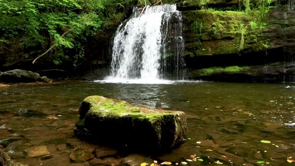 Wall Mural - 4k footage of a beautiful waterfall surrounded by lush green foliage in a forest (Sgwd y Pannwr, Brecon Beacons, Wales)