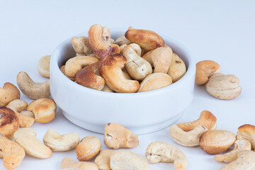 roasted cashew nuts in the bowl on white background