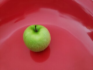 Green apple on a red background