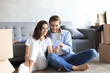© ty - Happy couple sitting and planning new home decoration at home with a smartphone at moving day, renovation and interior design for new house