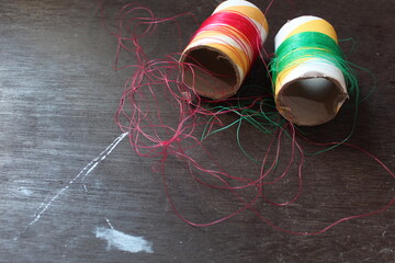 Blurred of tangled colored thread on a wooden background, image is noise / film grain