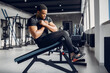 © prostooleh - Sports man in the gym. A black man performs exercises. Guy in a black t-shirt