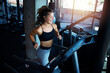 © littlewolf1989 - Top view of smiling woman exercising and training in the gym on treadmill running machine. Healthy lifestyle and positive people.