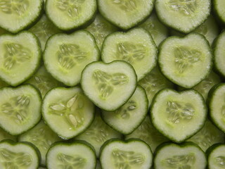 Wall Mural - Green color sliced cut raw heart shaped cucumber