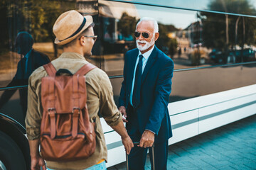 The bus driver accepts luggage from passenger.