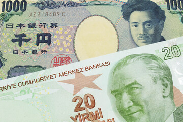 A macro image of a Japanese thousand yen note paired up with a green, twenty Turkish lira bank note.  Shot close up in macro.