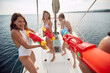 Friends playing with waterguns on a yacht
