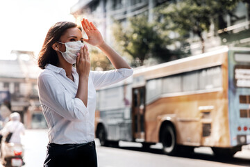 weather, pollution and ecology issue concept. young woman wearing protection mask against roadside i