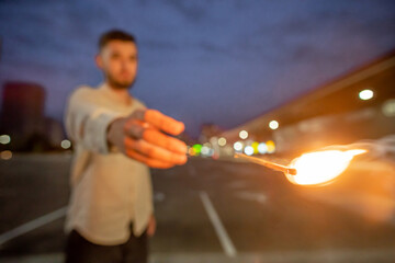 The man throws a burning matchstick, stop motion, selective focus.