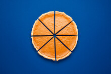 Sliced Pumpkin Pie Top View Isolated On Classic Blue Background. Homemade Cake.